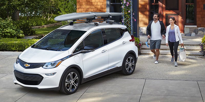 couple coming towards white Chevrolet Bolt EV